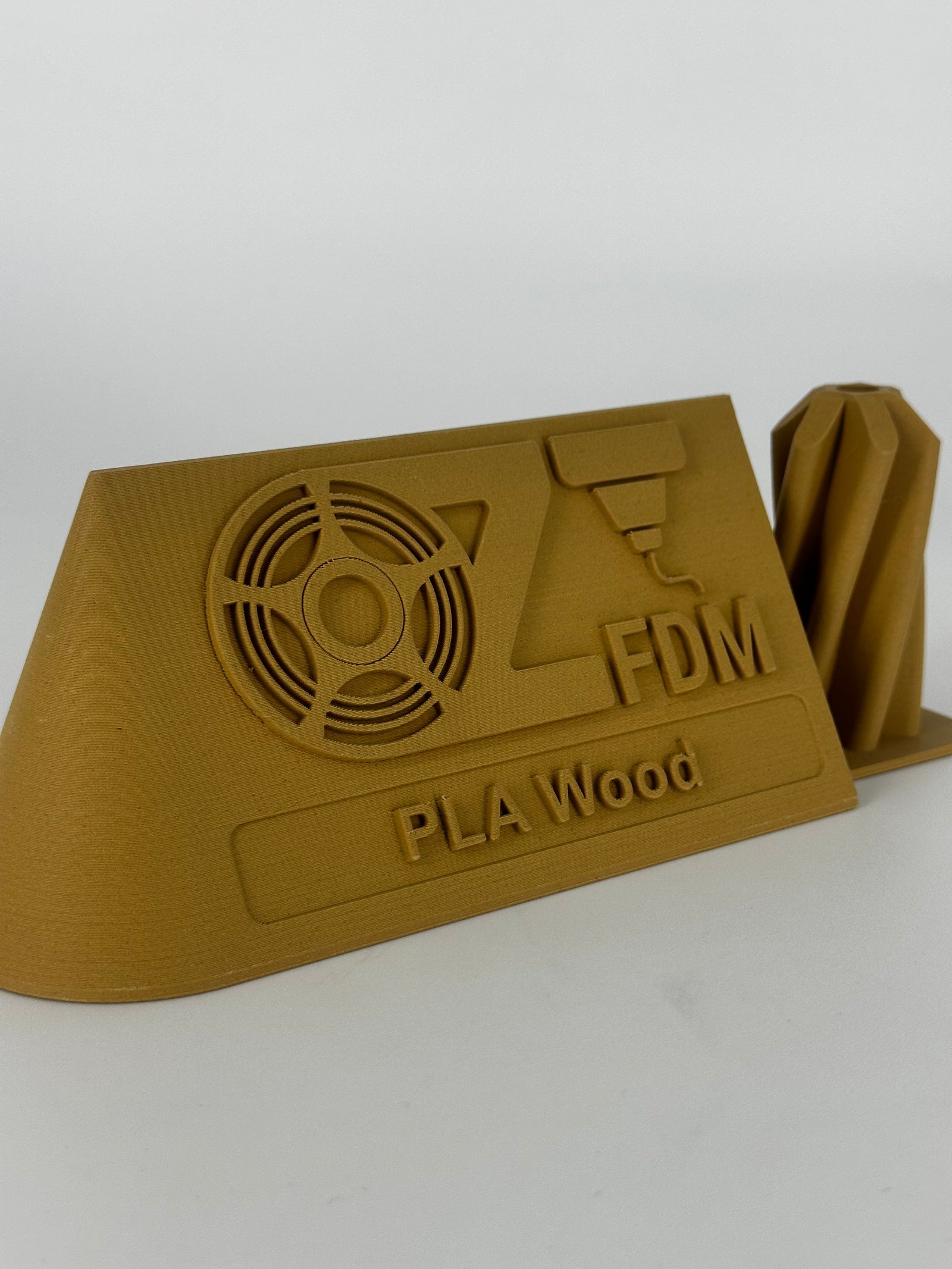 OzFDM logo plaque printed in PLA Wood showing the wood-grain finish