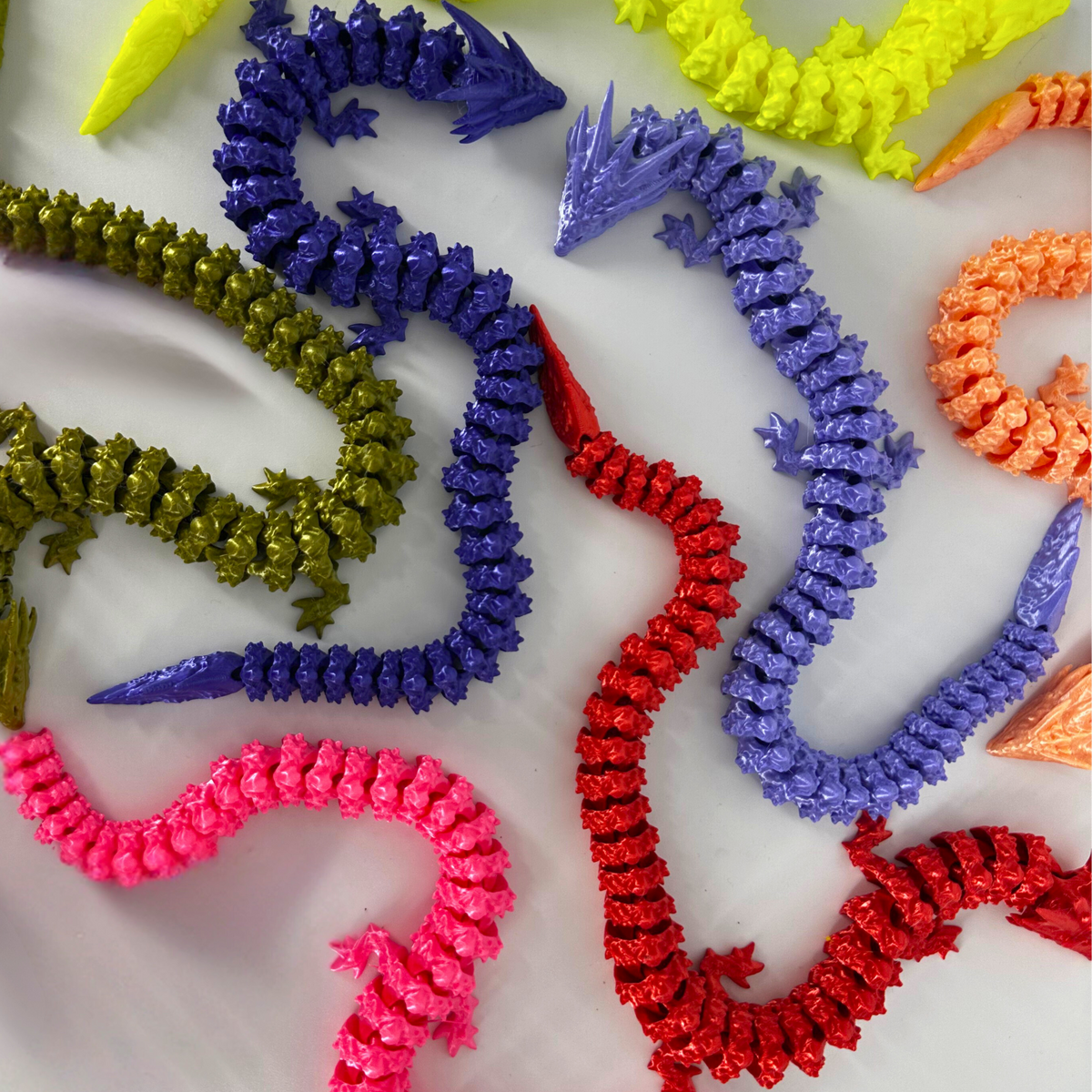 Articulated dragon and lizard prints in Silk PLA red, blue, gold and olive green