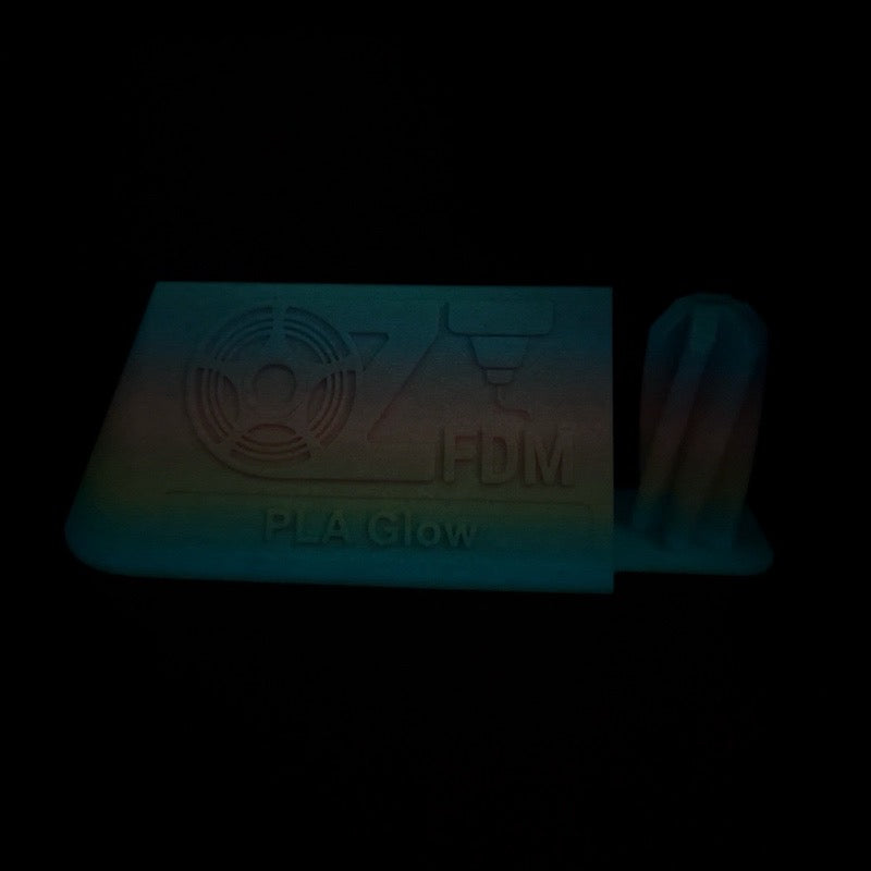 The same OzFDM PLA Glow rainbow plaque and vase glowing in darkness